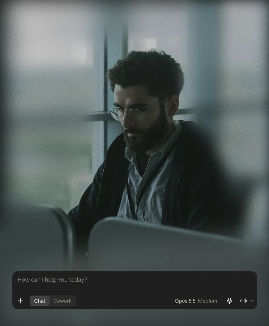 A man working at a desk by a window, with an AI assistant's prompt box reading How can I help you today?