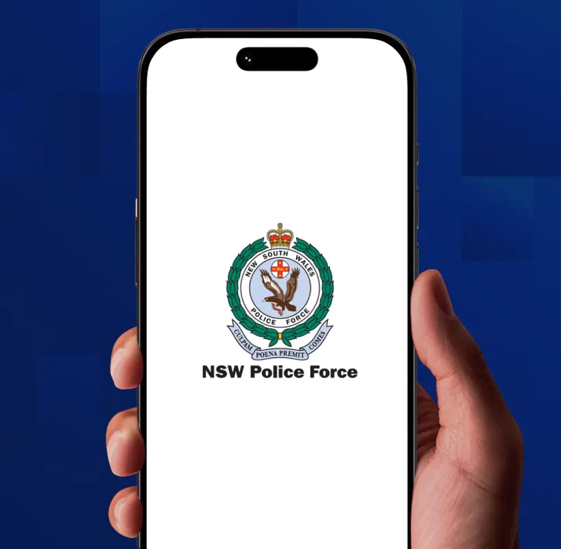 A hand holding a phone showing the NSW Police Force crest